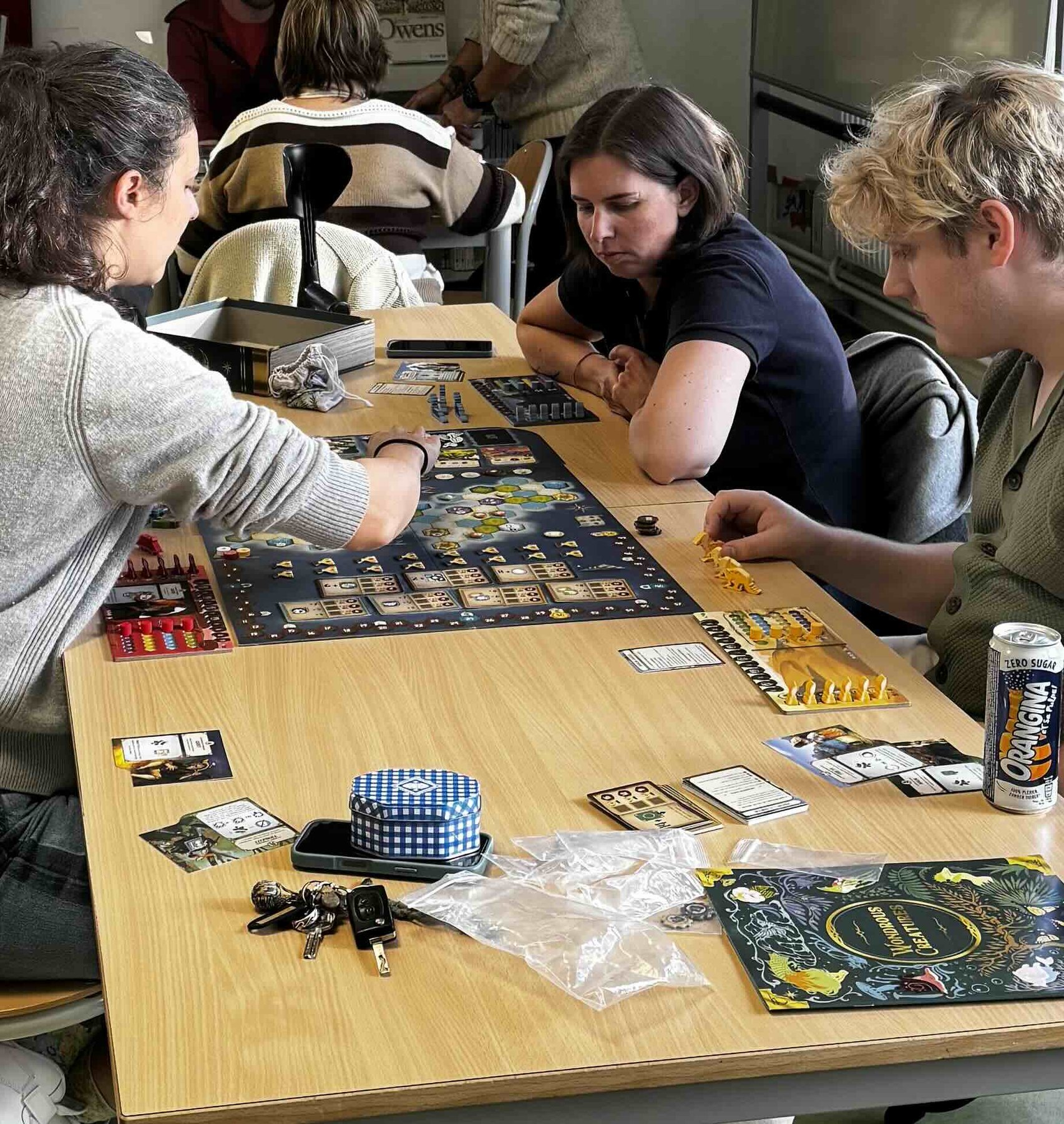 Joueuses et joueurs concentrés autour d’un jeu de plateau